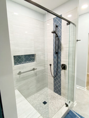 bathroom remodel with blue arabesque tile column shower accent