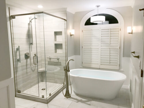 bathroom remodel with freestanding tub under arched window