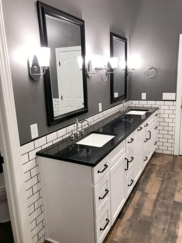 bathroom remodel with white cabinets and black countertop
