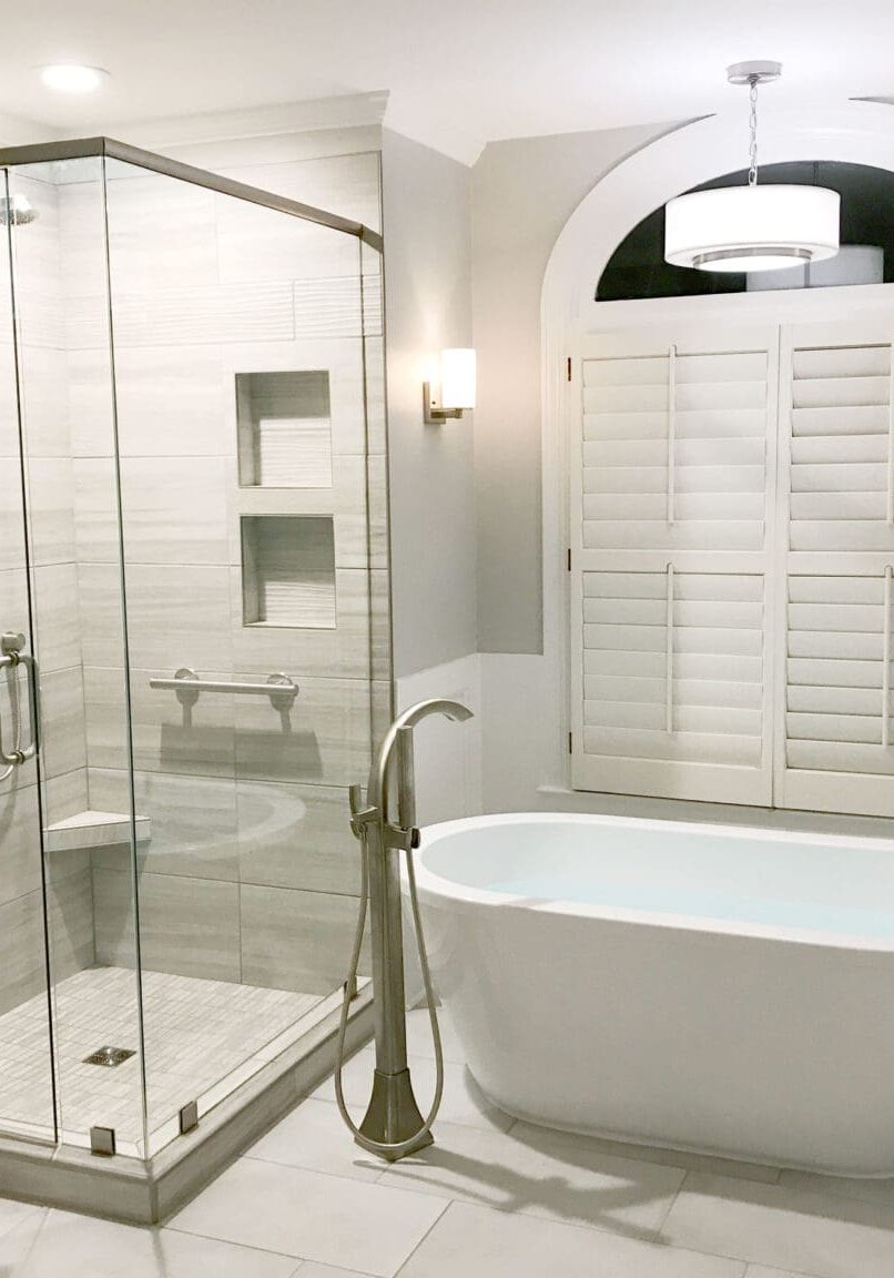 bathroom remodel with freestanding tub under arched window