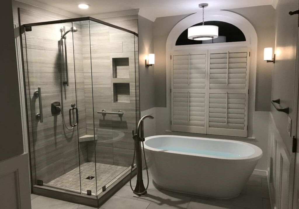 bathroom remodel with freestanding tub under arched window